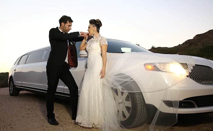 זוג בצילומי חתונה ליד לימוזינה זוג בצילומי חתונה ליד לימוזינה