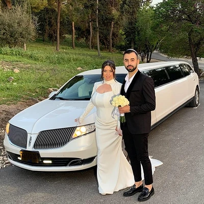 חתן וכלה מצטלמים עם הלימוזינה חתן וכלה מצטלמים עם הלימוזינה